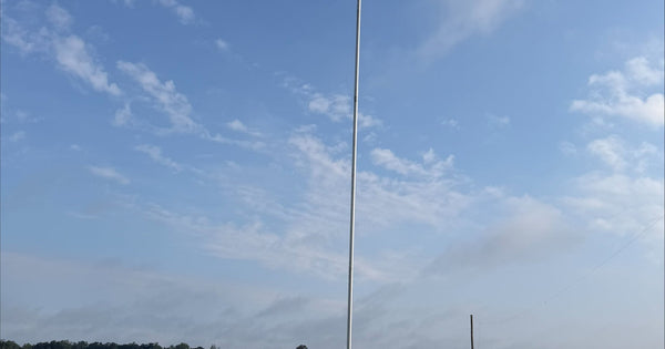 K1LDO's Greyline Skyline 33: a 24 ft DX Vertical topped with the 9 ft DX Whip, standing 33 feet against open North Carolina sky, raised by one person