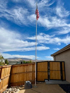 KB6FRD's 24-foot Greyline DX Flagpole antenna standing at full height against a clear blue Nevada sky, American flag flying, Spanish Springs, Nevada