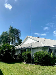 W3GF's 20-foot Greyline flagpole with the 9-foot DX whip on top, against a Florida sky