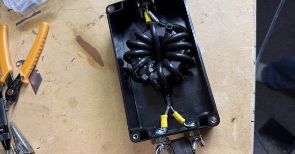 Homebrew common-mode choke - coax wound through stacked ferrite toroids in a weatherproof enclosure, the RF half of what ground actually means