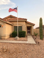 An elegant, partner-approved Greyline flagpole antenna blending seamlessly into a desert landscape yard.